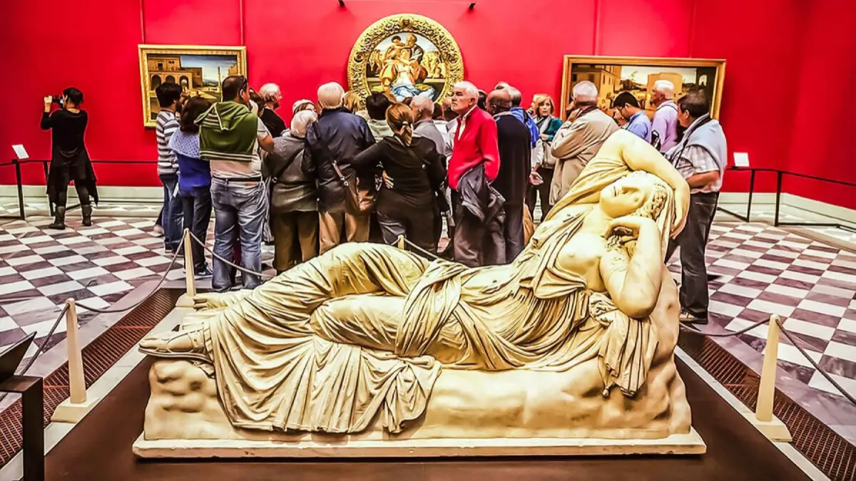 Marble statue at the Uffizi Gallery Visitors viewing artwork in the Uffizi Gallery with a reclining marble statue in the foreground