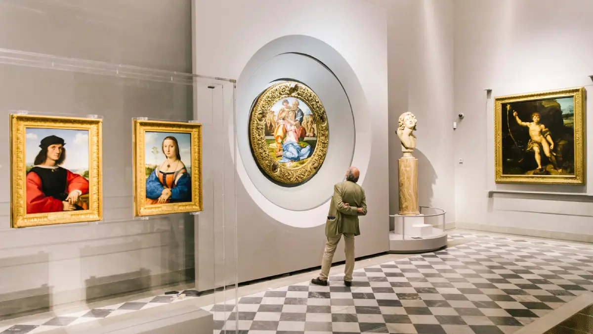 Paintings display at the Uffizi Gallery A person looking at the paintings at the Uffizi Gallery