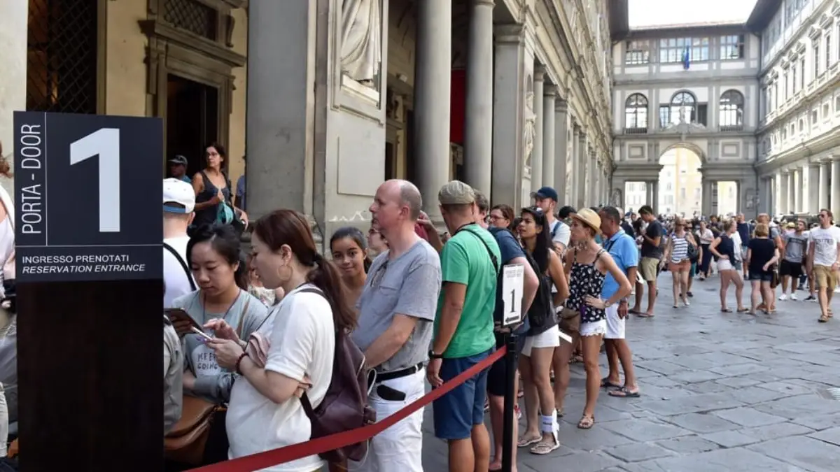 Numerous number of people standing in aline outside the Uffizi gallery for the entry Numerous number of people standing in aline outside the Uffizi gallery for the entry